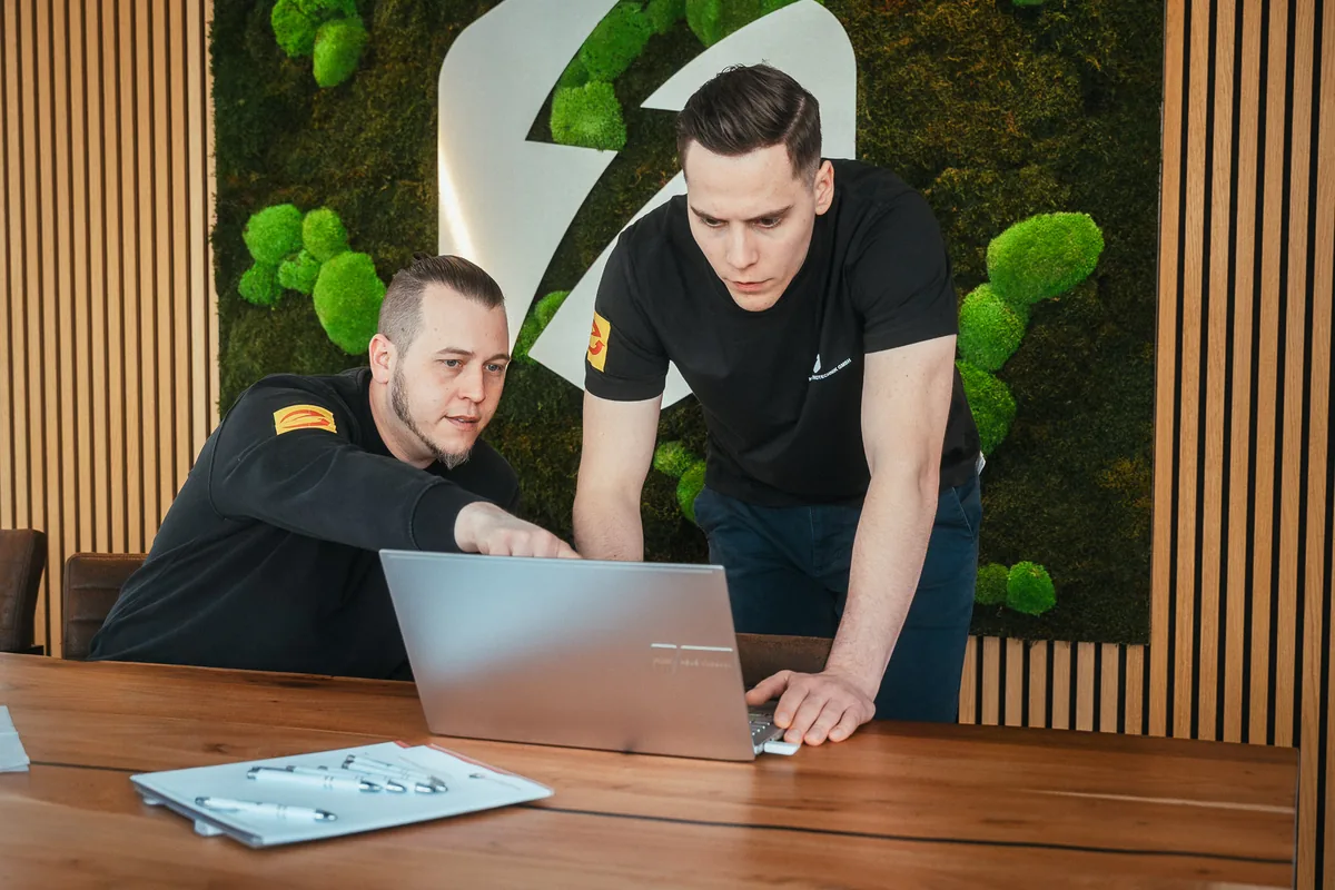 Robin und Marco Kleber bei der Betriebsführung am Laptop