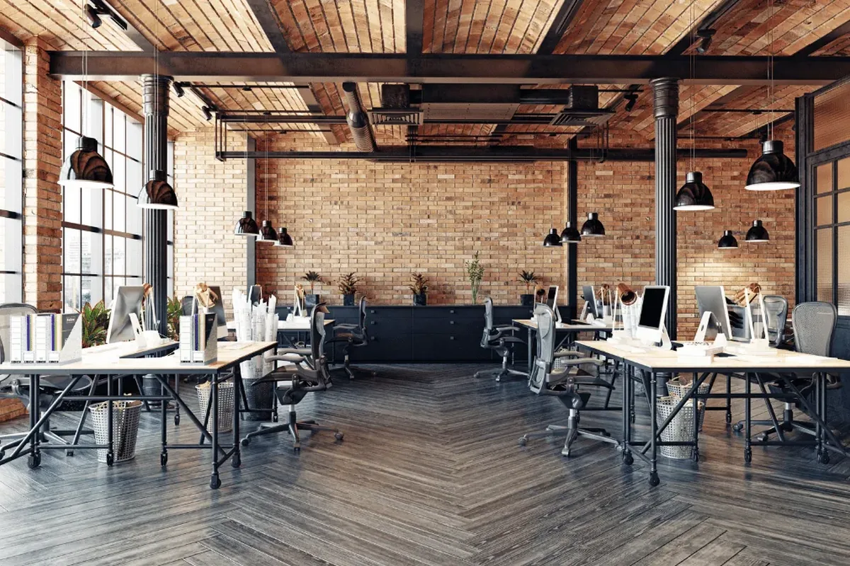 Modernes Loft-Büro mit Backsteinwänden, Pendelleuchten und normgerechter Arbeitsplatzbeleuchtung