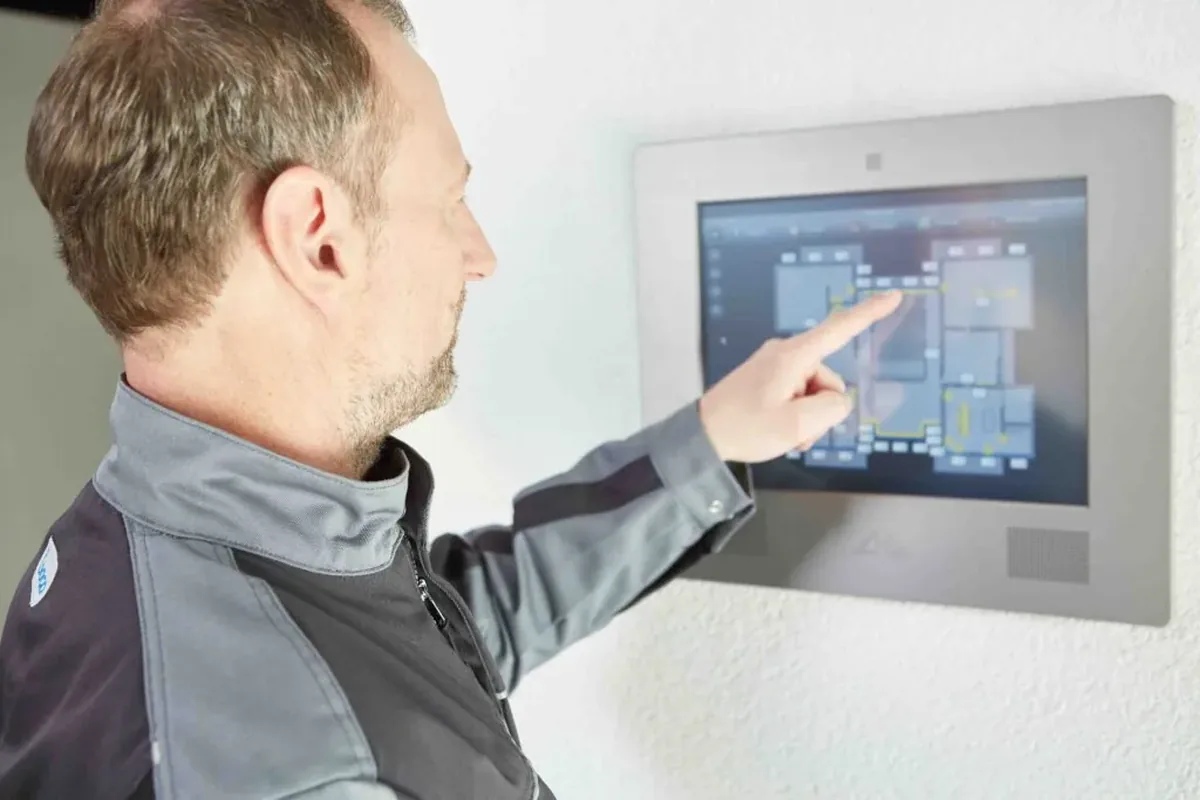 Techniker bedient ein KNX-Touchpanel zur Gebäudesteuerung